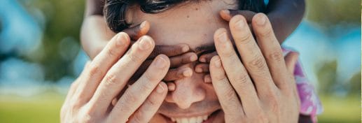 man with hands on eyes